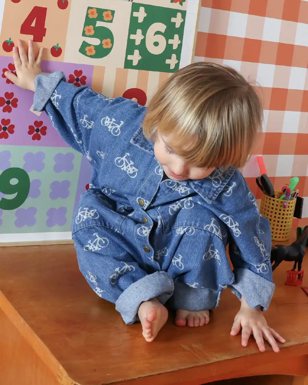 Enfant dans sa chambre avec une affiche Ma Petite Vie illustrant nos bons pour enfants à offrir