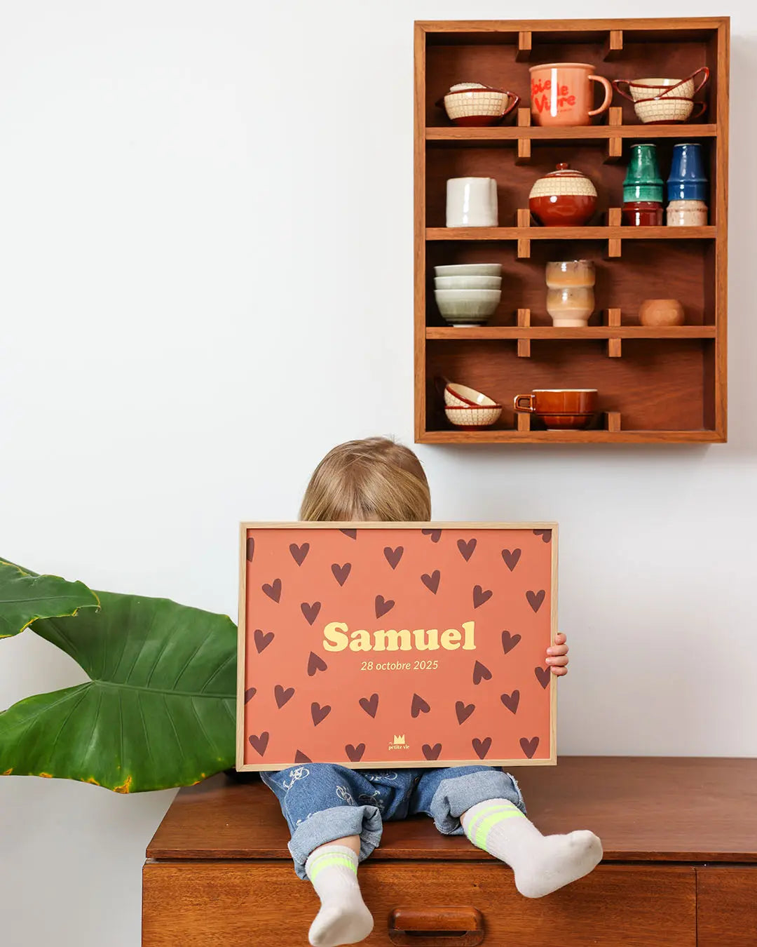 Affiche prénom enfant portée par un bébé pour une décoration esthétique et colorée