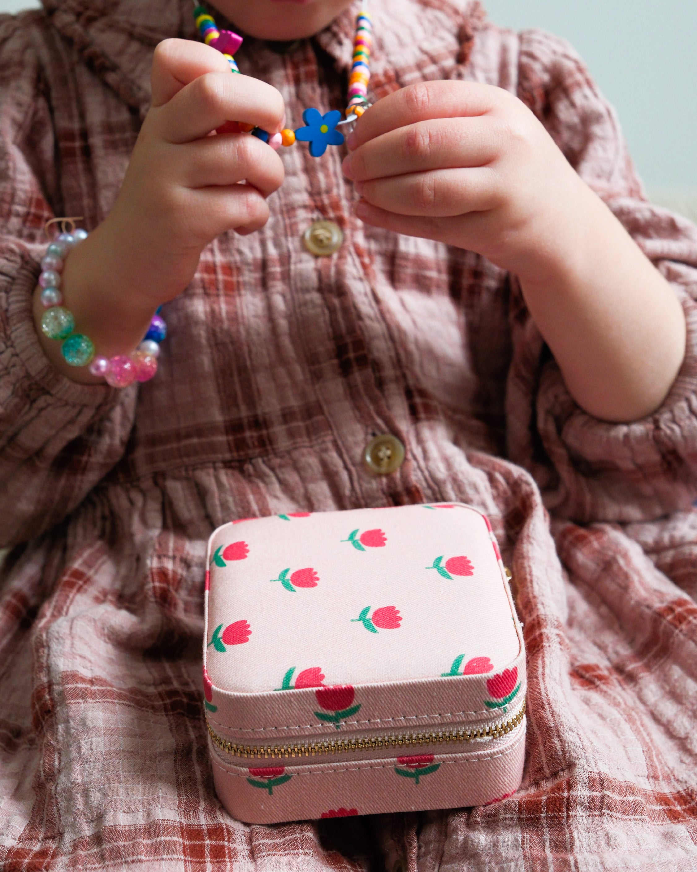 enfant qui tient un collier pour le ranger dans sa boite à bijoux Ma petite vie